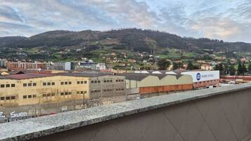 Une vue d’une ville avec des bâtiments, une colline et un panneau indiquant « Gomez Ovejo ».