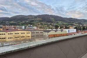 A view of a town with buildings, a hill, and a sign for 'Gomez Ovejo.'