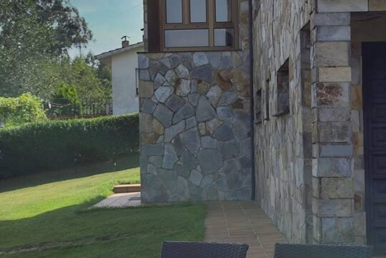 A stone exterior wall with a window and a door.