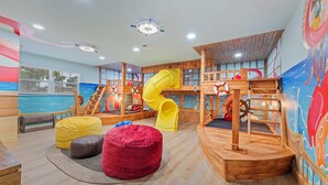 Un espace de jeux pour enfants avec des toboggans et une structure de jeu sur le thème d’un navire.