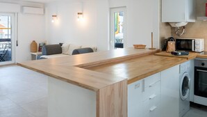 Een moderne keuken met een centraal eiland, inbouwapparatuur en uitzicht naar buiten.