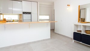 Een moderne keuken met witte kastjes, een houten aanrecht en een ingebouwde oven.