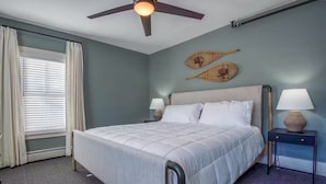 A hotel room with a bed, two bedside tables, a ceiling fan, and a window with curtains. - Home in Heart of Downtown North Conway (Conway)