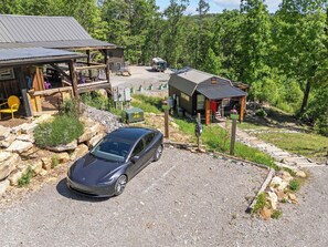 A gravel driveway leading to a building with a metal roof, surrounded by trees and a parked car. - Mountaintop Retreat - central hiking & activities (Chattanooga)