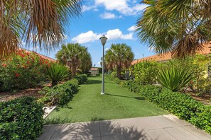 A well-maintained garden pathway with a central lamp post, surrounded by lush greenery and flowering plants. - Casa Sirena — Your Peaceful Curaçao Hideaway (Willemstad)