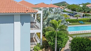 Un hôtel doté d’une piscine, de palmiers et offrant une vue sur un paysage vallonné.