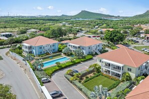 A residential area with houses, a swimming pool, and a road. - Casa Felicidad at Blije Rust | Tropical Escape (Sint Michiel)
