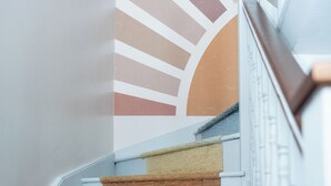 Una escalera con un revestimiento mural estampado y barandilla de madera.