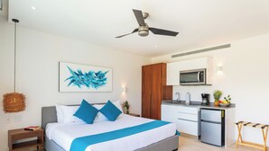 A modern bedroom with a bed, bedside table, and a ceiling fan. - Warm Studio Lagoon View CPL D202 (Tulum)