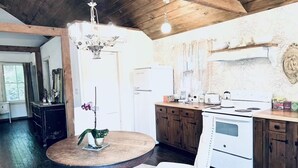 Eine rustikale Küche mit Holzausstattung, einem weißen Herd und einer Kronleuchter.