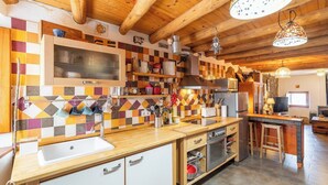 A kitchen with a checkered tile backsplash, wooden cabinets, a stainless steel sink, and a built-in oven. - La Pelotilla Genalguacil by Ruralidays (Málaga)