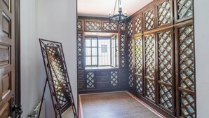 A room with traditional wooden lattice partitions, a large window, and a hanging light fixture.