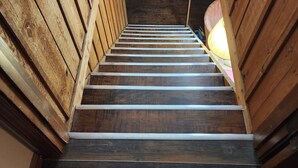 Eine Holztreppe mit Metallgeländern, die zu einer höheren Etage führt.