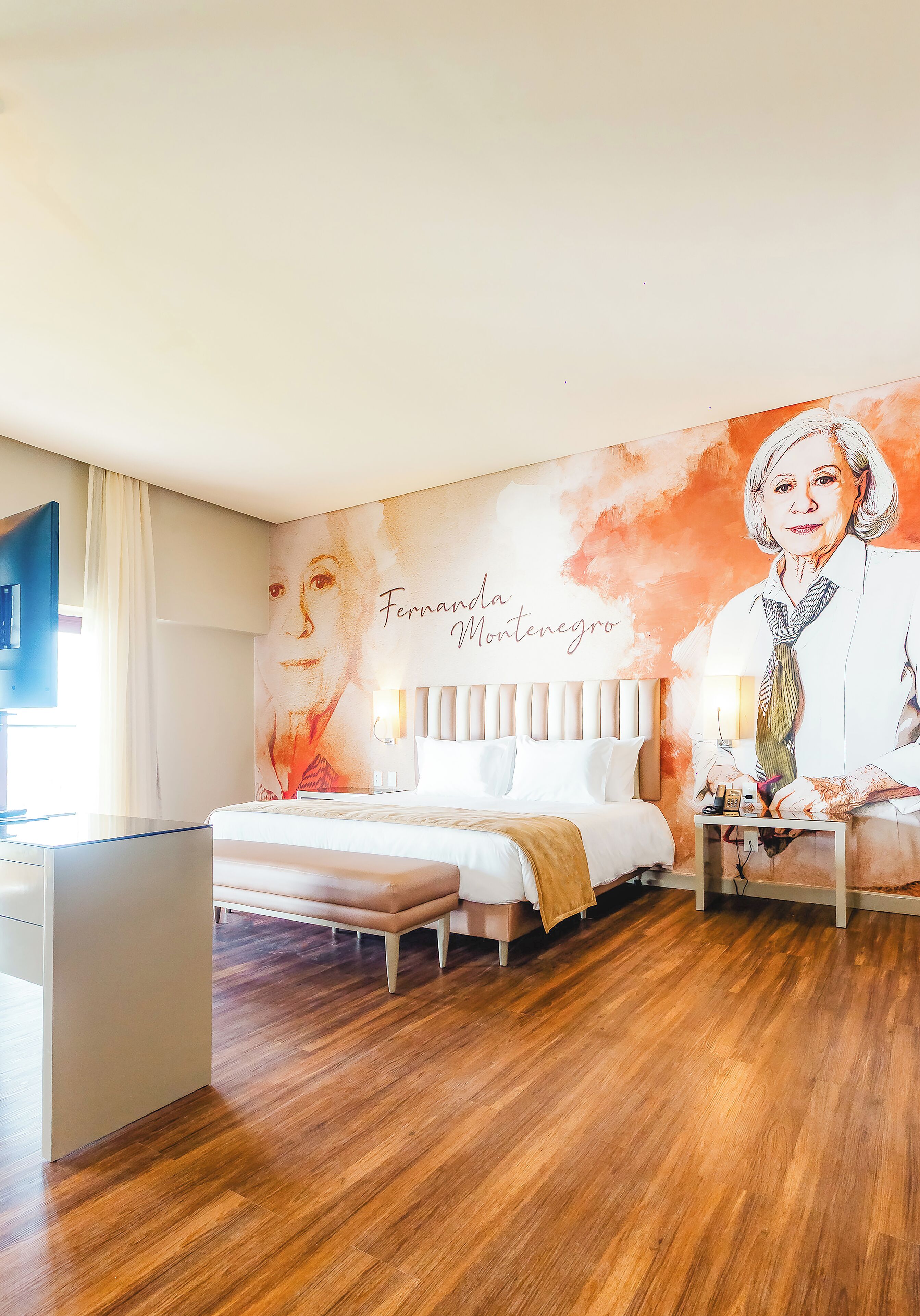 A hotel room with a bed, bedside table, and a wall mural.