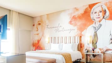 Ein Hotelzimmer mit Bett, Nachttisch und Wandgemälde.