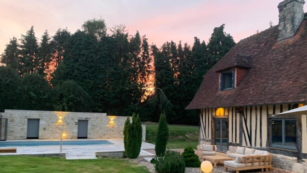 A modern house with a swimming pool, a patio with outdoor furniture, and a stone wall. - Serene villa with heated and covered pool in Le Brévedent (Le Brévedent)