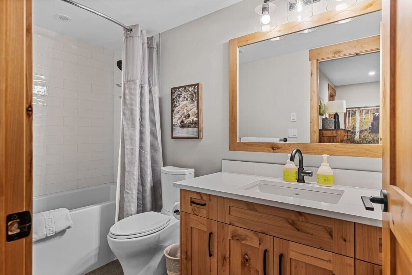 Une salle de bain équipée d’une douche, de toilettes, d’un lavabo et de meubles en bois.