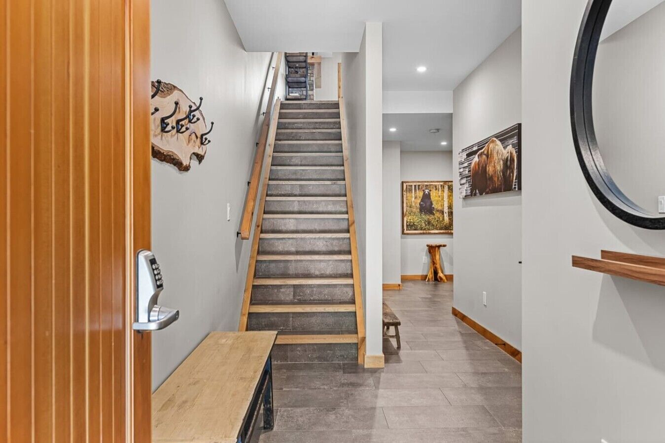 Un escalier avec une rampe en bois et une serrure de porte fixée au mur.