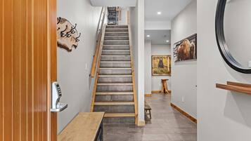 Un escalier avec une rampe en bois et une serrure de porte fixée au mur.