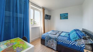 A bedroom with a bed, a TV, a window, and a table. - Le Crépuscule - Wifi - Balcon (Créteil)