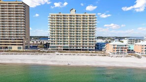 A high-rise hotel with multiple balconies, located adjacent to a beach. - Crystal Shores 1003 (Gulf Shores)