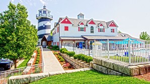 Un bâtiment situé au bord de l’eau, doté d’un phare, d’une piscine et d’une terrasse couverte.