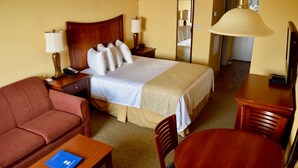 A hotel room with a bed, a sofa, a desk, a chair, and a table. - Ocean View Studio + Mini Kitchen in Myrtle Beach (Myrtle Beach)