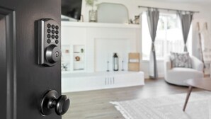Un interno moderno con una porta nera dotata di tastierino numerico e pomello rotondo.