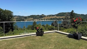 A balcony with a clear view of a lake and surrounding hills. - L'EMERAUDE suite lake view / swimming pool / beach 10 min walk away (Bilieu)