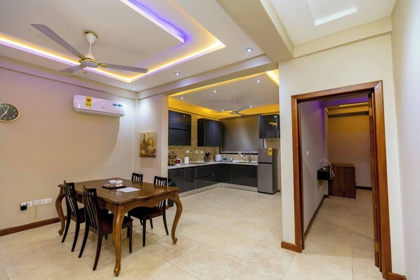 A modern kitchen with dark cabinets, a built-in oven, and a refrigerator.