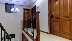 A staircase with wooden railings and a chandelier, leading to a room with wooden doors and a number "3" sign. - Davina's Villa - Beloved Retreat Studio Apt2 (Kumasi)