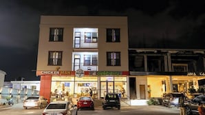 A multi-story building with a ground floor restaurant named "Chicken Man" and a second-floor restaurant named "Pizzaman." - Davina's Villa - Beloved Retreat Studio Apt2 (Kumasi)