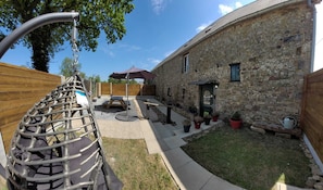 Un edificio in pietra con un patio, un'amaca e piante in vaso.