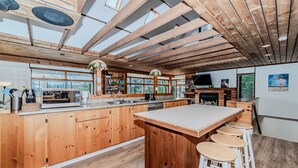 A spacious kitchen with wooden cabinets, a large island, and a dining area with stools.