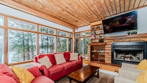 A cozy living room with a red sofa, wooden coffee table, and a fireplace.