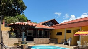 Una propiedad residencial con piscina, sillas de descanso y mobiliario de exterior.