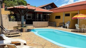 Il s’agit d’une propriété résidentielle dotée d’une piscine, de chaises longues et de mobilier d’extérieur.