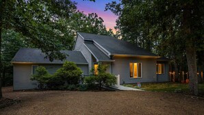 A two-story house with a sloped roof, a front porch, and a well-maintained yard.