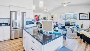 A modern kitchen with stainless steel appliances, a marble countertop island, and a dining area with a black and white patterned table. - The Grape Escape/Luxury Stay/Views/Walk 2 Old Town (Cottonwood)