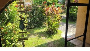 Un jardin avec différentes espèces de plantes et un chemin menant à un bâtiment.