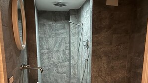 A modern bathroom with a freestanding bathtub, a sink with a bowl, two rolls of toilet paper, a bidet, and a mirror. - Becial house (Napoli)