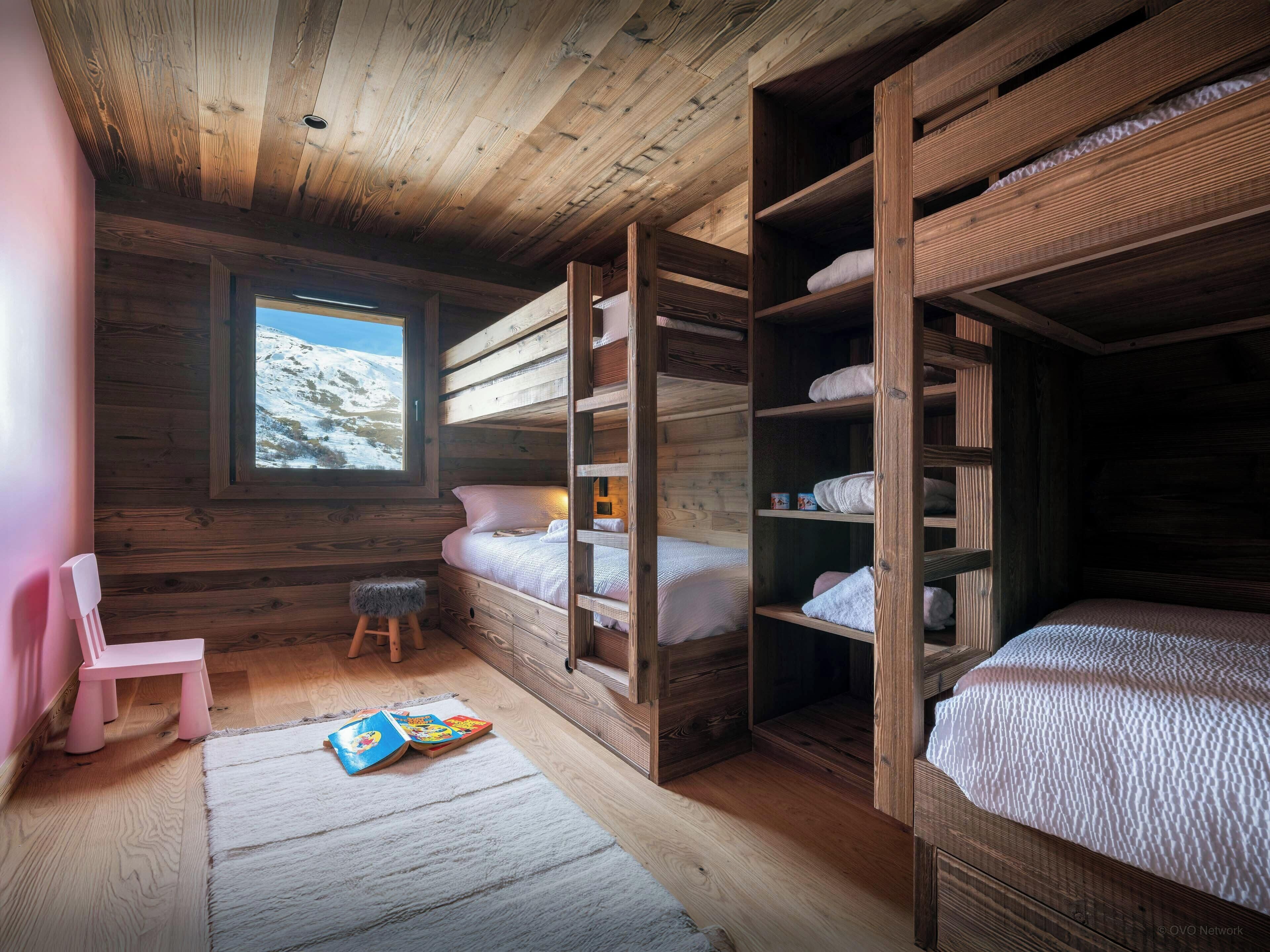 A cozy cabin room with wooden walls and a bunk bed.