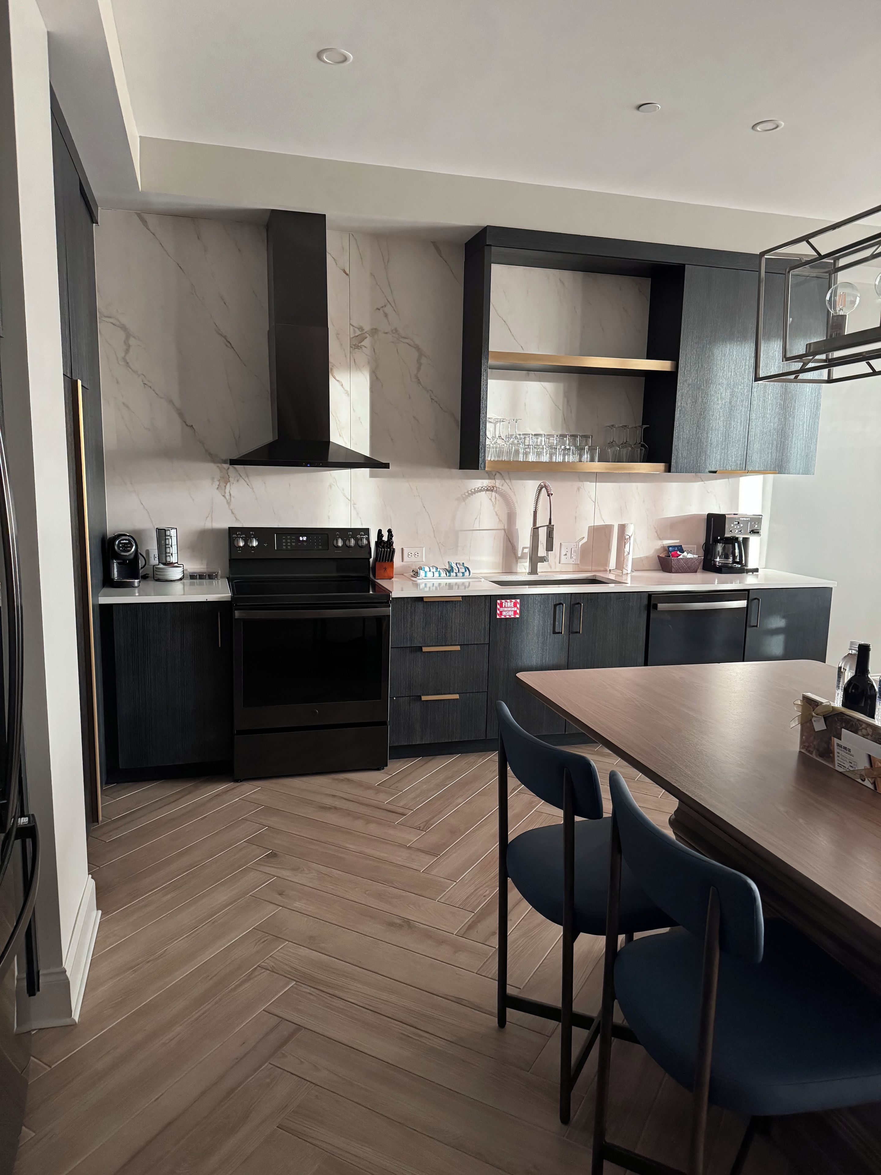 A modern kitchen with a built-in oven, a coffee maker, and a sink.
