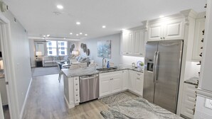 A modern kitchen with white cabinetry, stainless steel appliances, and a marble countertop. - Luxurious 2BR Gulfview Condo On Siesta Key Steps To The Beach Gulf Horizon (Sarasota)