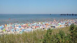 A crowded beach with numerous colorful umbrellas and beachgoers. - Mobile Home in Rogowo Near Baltic Beach (Trzebiatow)