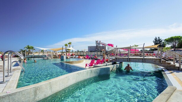 A clear swimming pool with multiple lanes, a water slide, and lounge chairs. - Mobile Home in Serignan With air Conditioning (Sérignan)