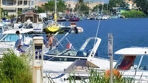 A marina with various boats docked, a building with balconies, and a clear view of the water. - Mobile Home in Serignan With air Conditioning (Sérignan)