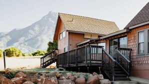 En toetagers bygning med træfacade, en balkon og en trappe op til øvre etage.
