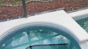 A hot tub with a tiled edge and a drain. - Charming 3-bedroom house with WiFi, AC, Pool, Lake View, by Disney. (Kissimmee)