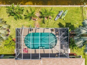 Ein Luftbild eines Dachpools mit umliegenden Palmen und zwei Kajaks.
